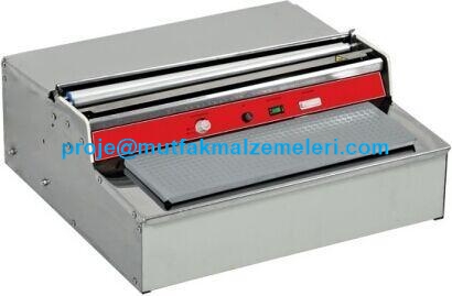 555x440x240 mm ölçülerinde, parlak paslanmaz çelik gövdeli profesyonel streçleme makinesi. Üst kısmında film koruma kapağı, ön tarafta sıcak kesme teli ve geniş ısıtıcı taban plakası bulunan, tezgaha uygun kompakt gıda paketleme ekipmanı.